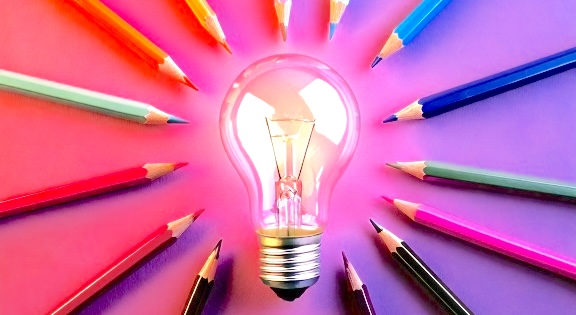 Coloured pencils around a lightbulb.